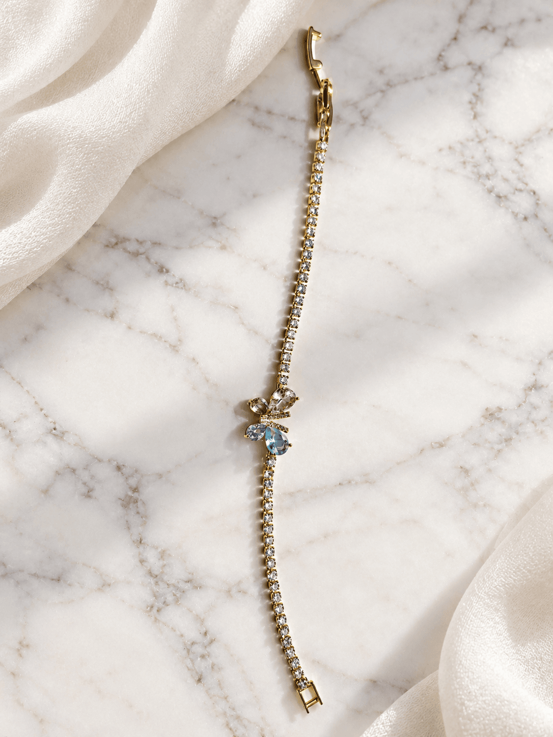 Crystal flower tennis bracelet on marble with ivory shawl